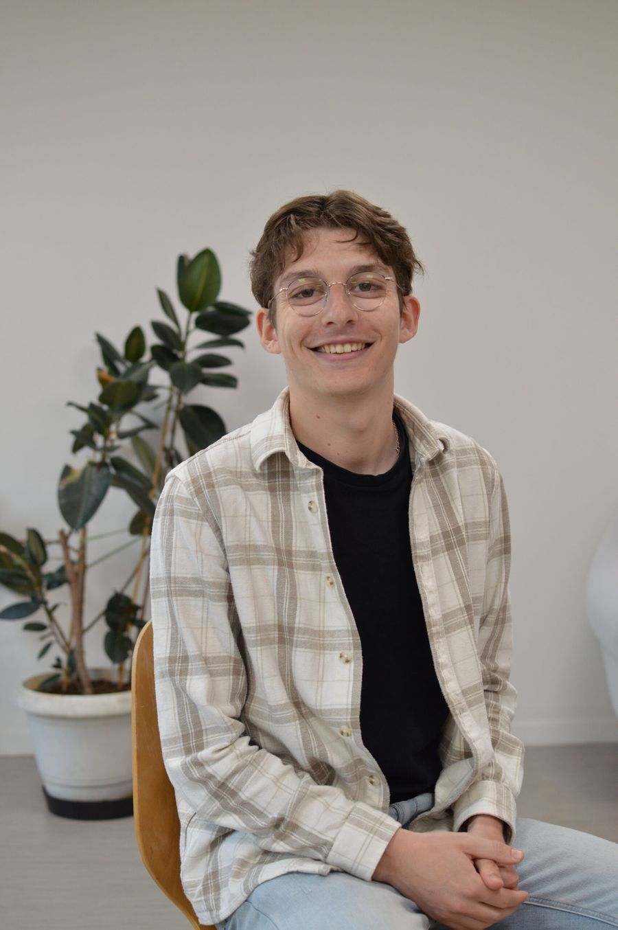 Portrait de Loris Combe, souriant, dans un espace de travail lumineux